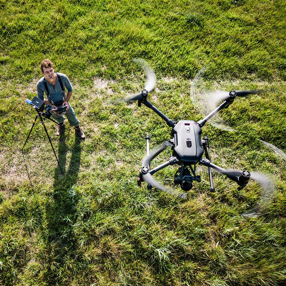 Dronepiloot op het veld in de ochtend